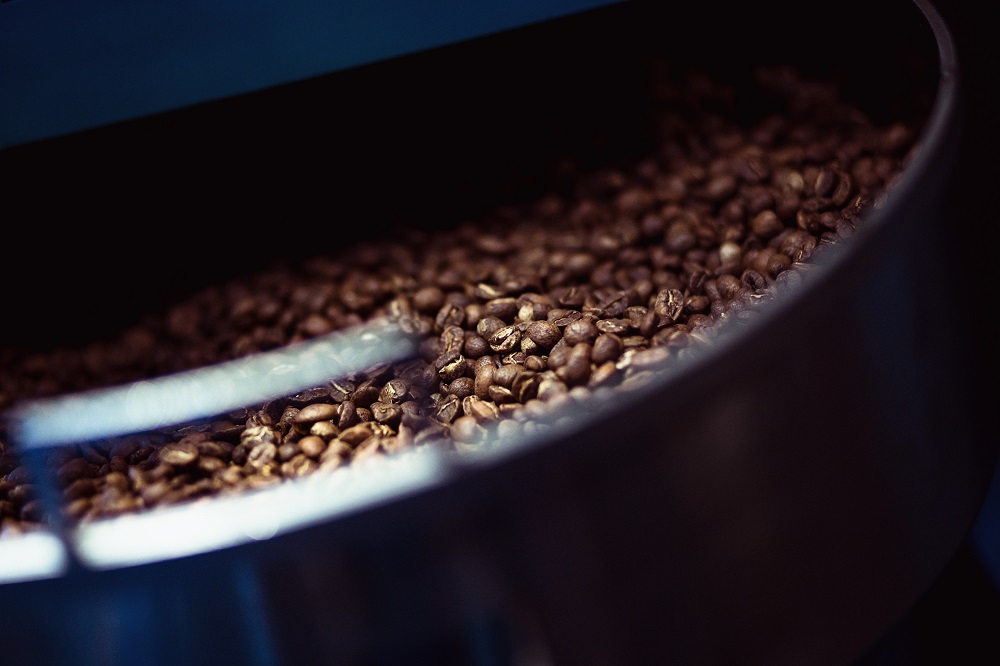 Partial view of a tray of freshly roasted coffee beans.